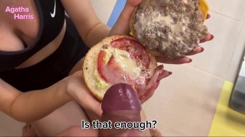 Uma loira de óculos faz um boquete na amiga enquanto segura um hambúrguer.