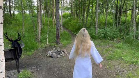 Uma loira está caminhando na natureza