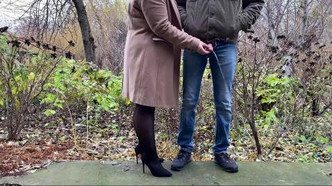 Uma esposa de meias pretas caminha com o marido na rua