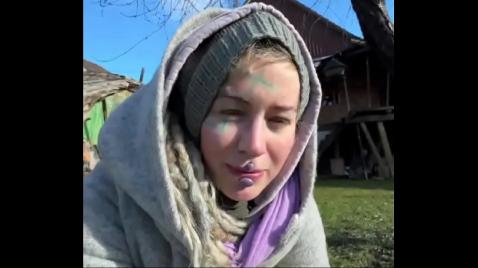 Uma loira está caminhando pela rua com um casaco quente.